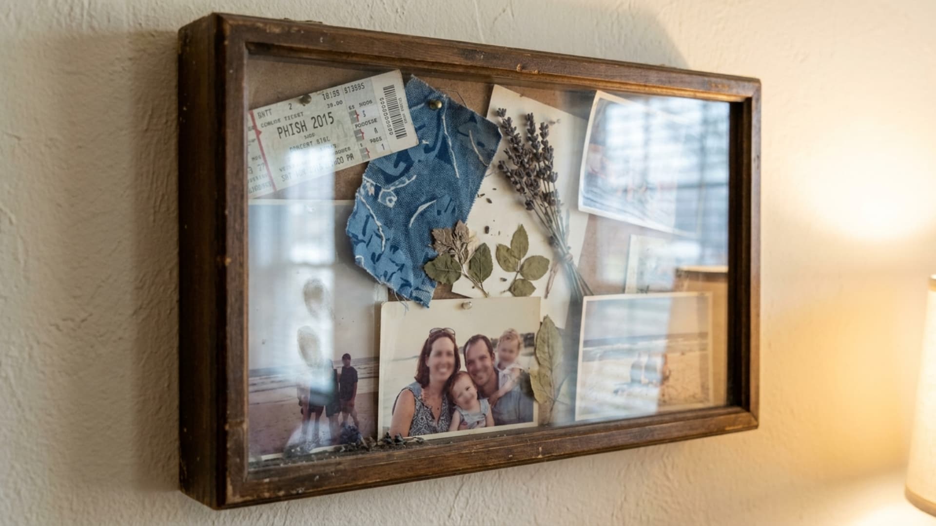 shadow box memory display with mementos and photos mounted on living room wall