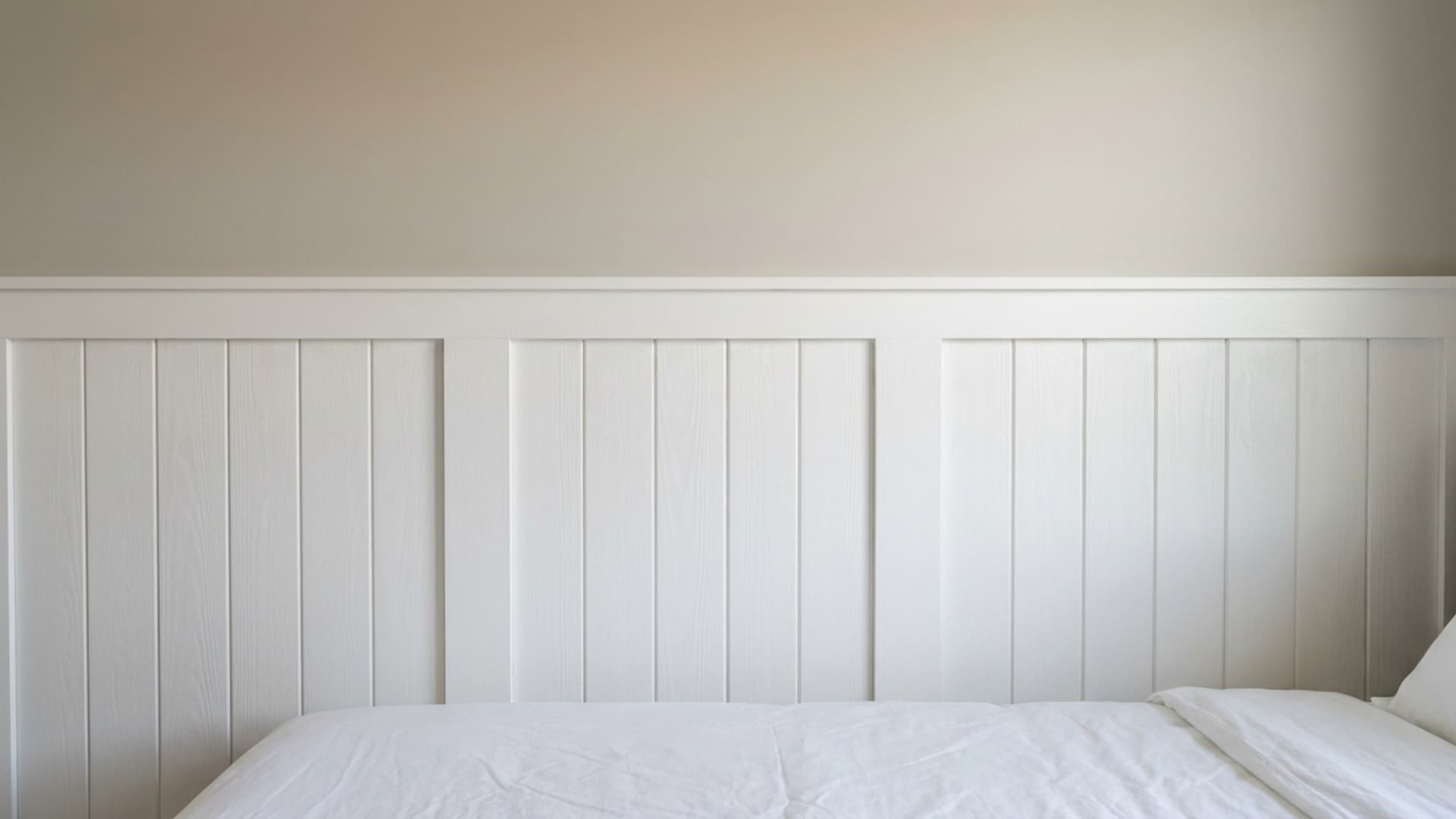 crisp white board-and-batten paneling on lower wall with warm greige paint above