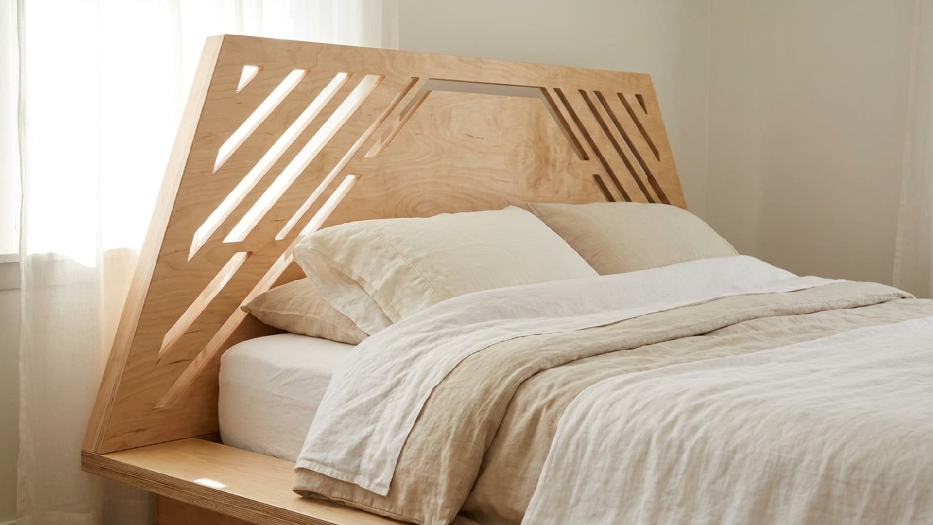 angular wood cutout headboard in a trapezoid shape behind a bed