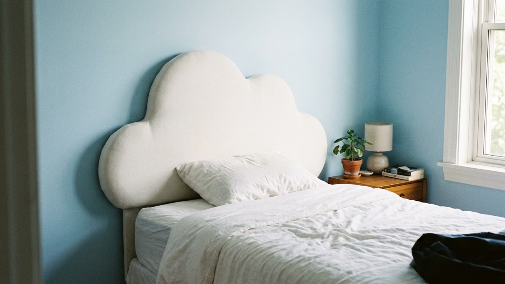 cloud shaped headboard behind pillows in a kids bedroom