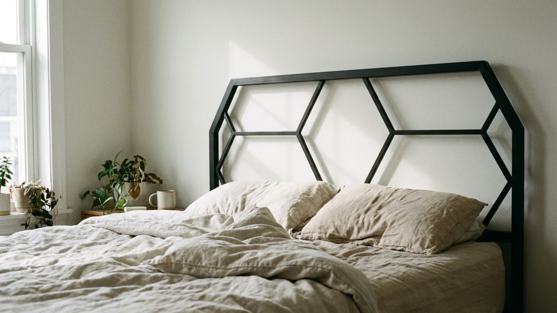 geometric metal frame headboard in black behind a bed