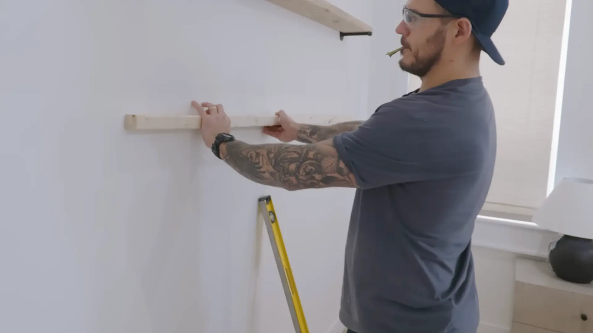 sliding a stained wood shelf board onto mounted wall rods
