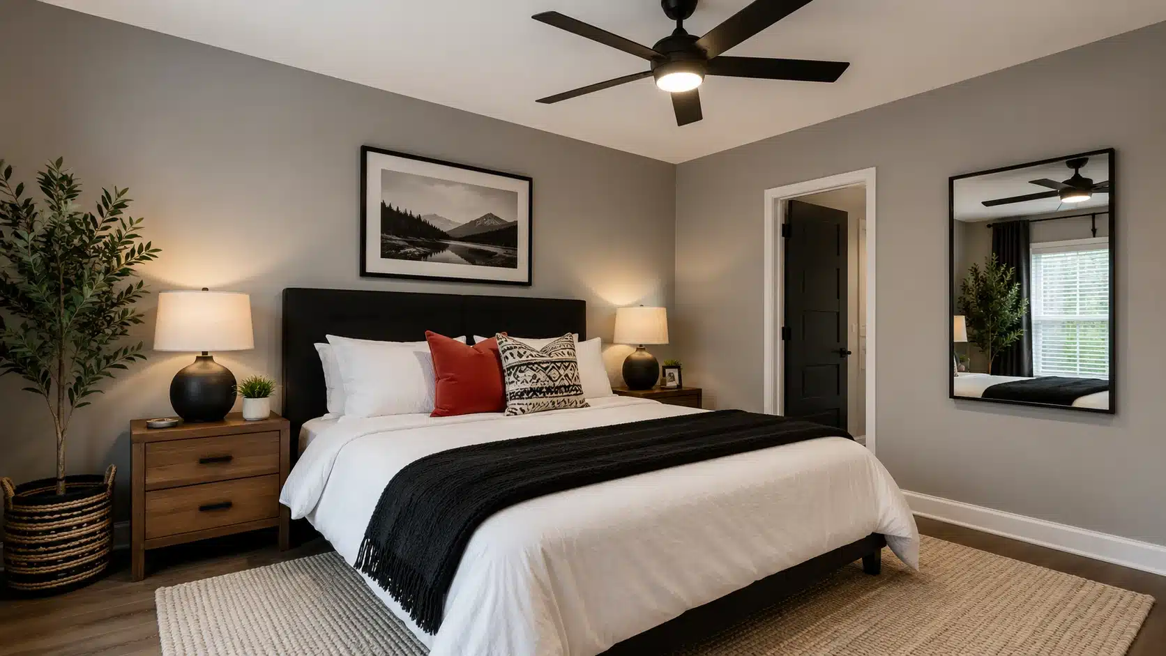 modern bedroom with a king-size bed, gray walls, black ceiling fan, and landscape artwork