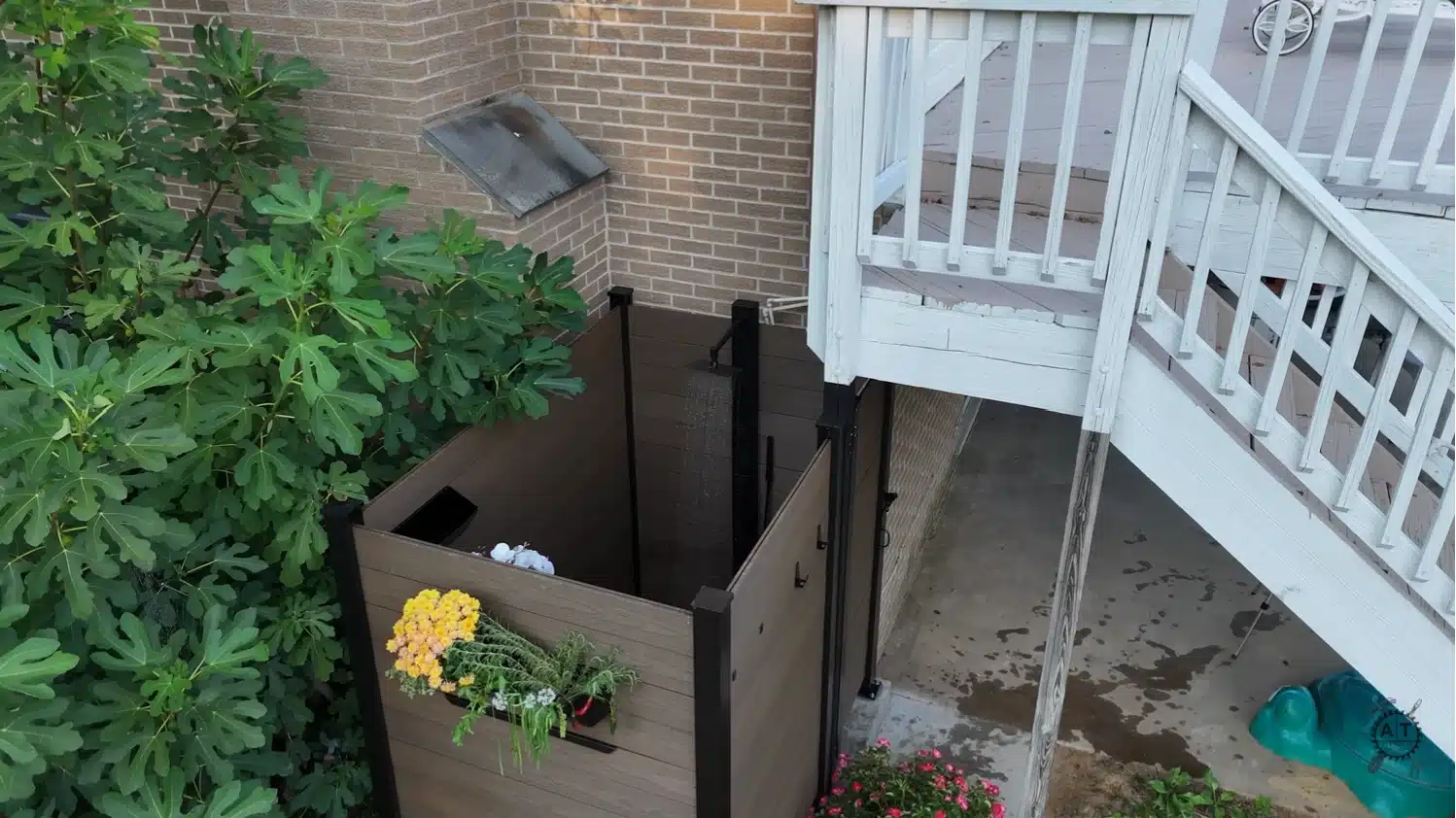 aerial view of a finished wood and composite outdoor shower with running showerhead