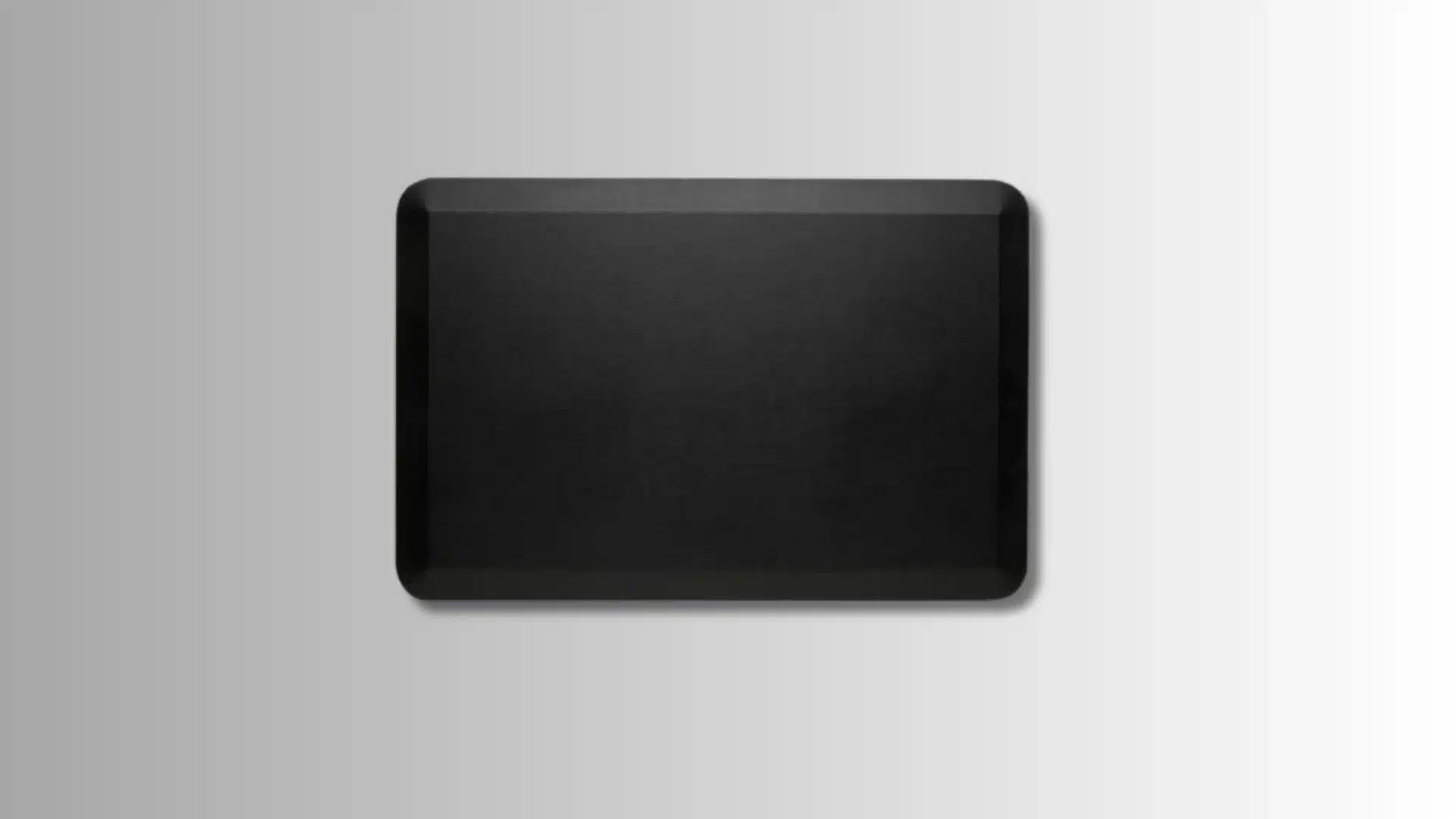 black rectangular anti-fatigue mat with beveled edges on a gradient background