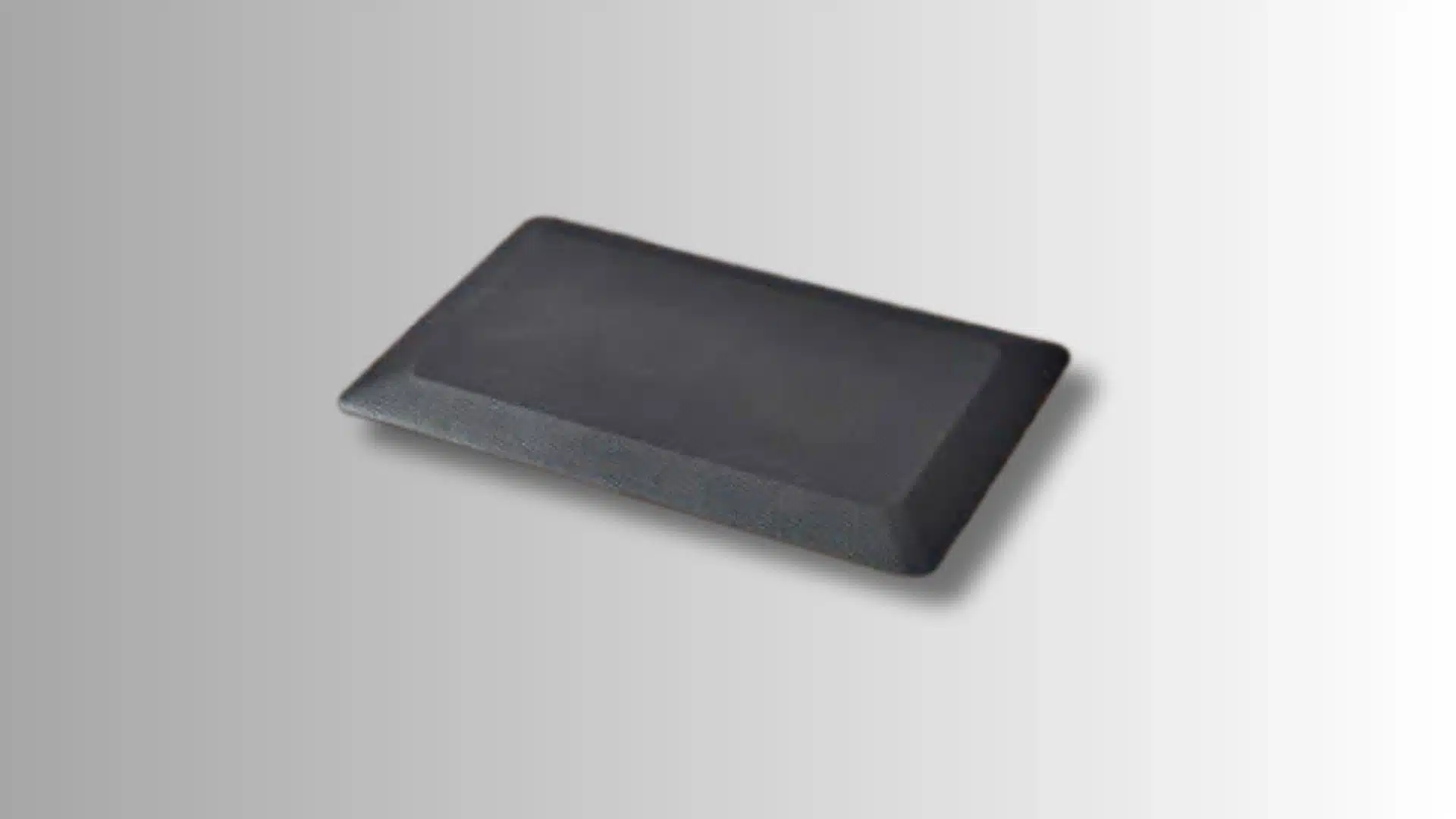 black rectangular anti-fatigue mat with raised edges on a gradient background
