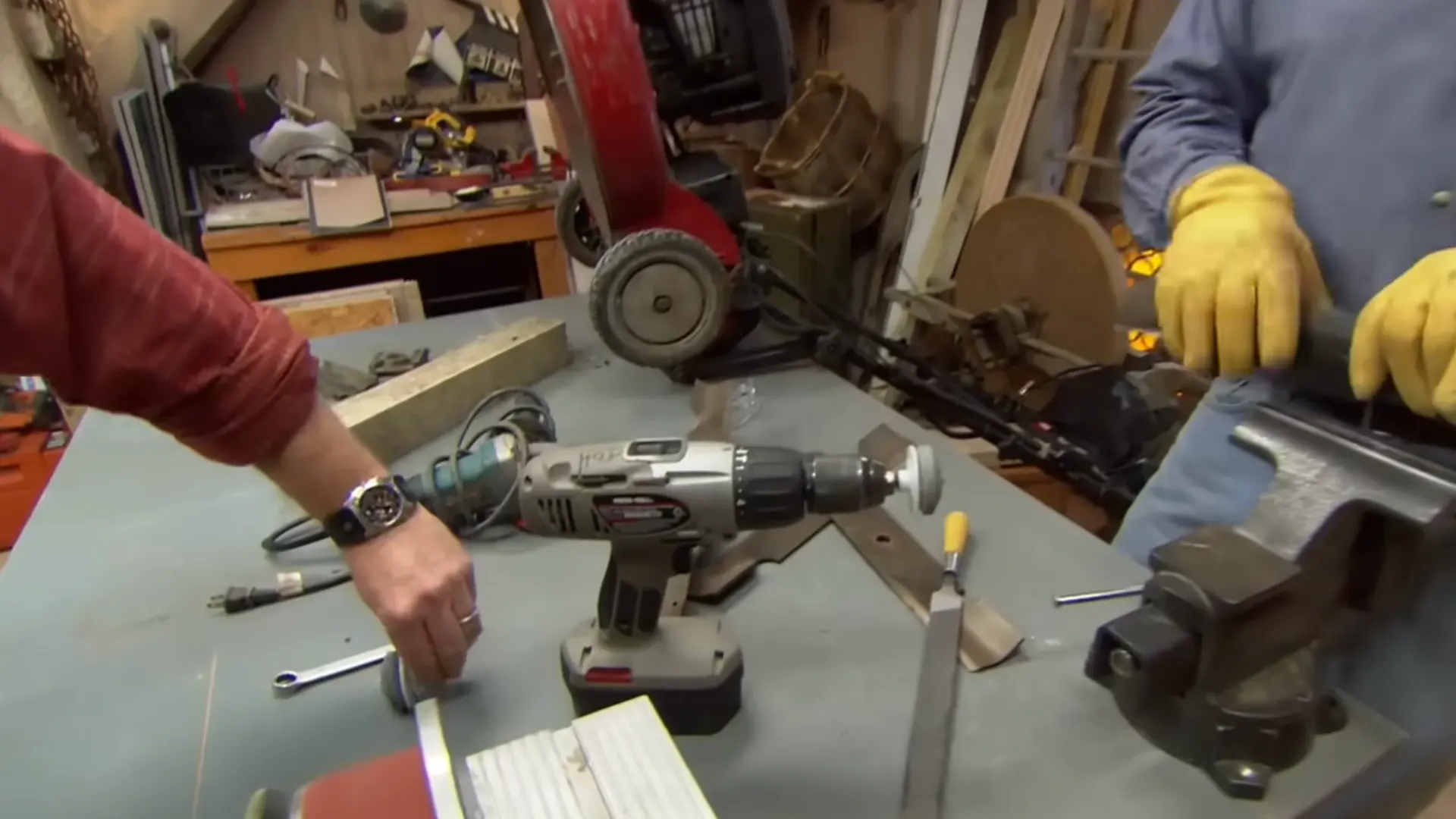 cordless drill with a blade sharpening attachment set up on a workbench