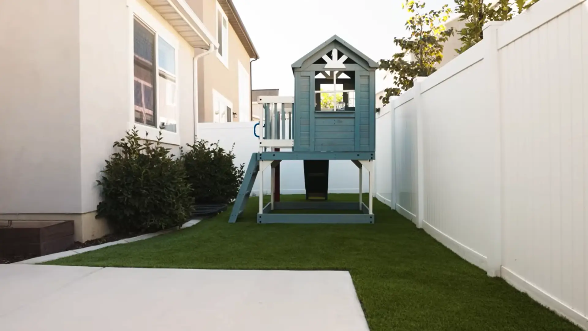 freshly installed artificial grass with upright fibers, clean edges, and a tidy landscaped backyard