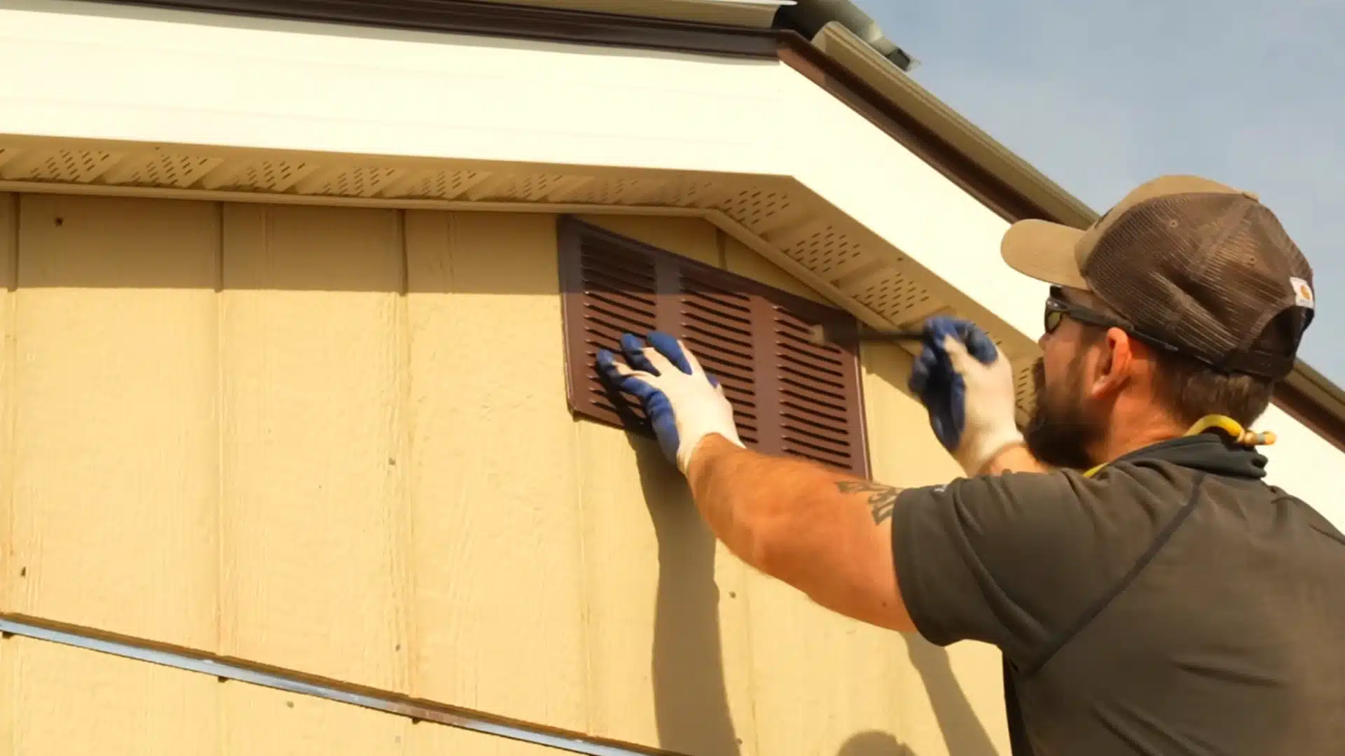 gable vent installation with brown vent secured under roof peak on shed