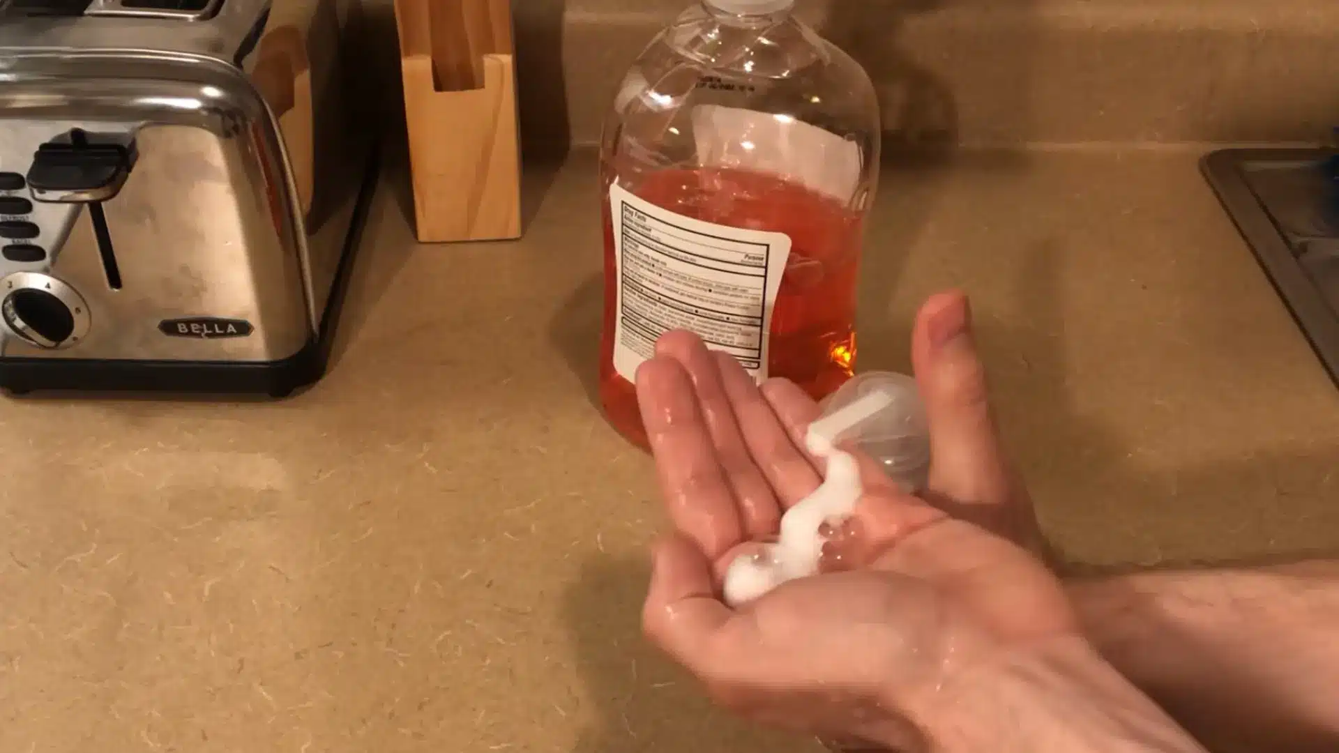 hand pumping homemade foaming soap into palm to test the foam texture