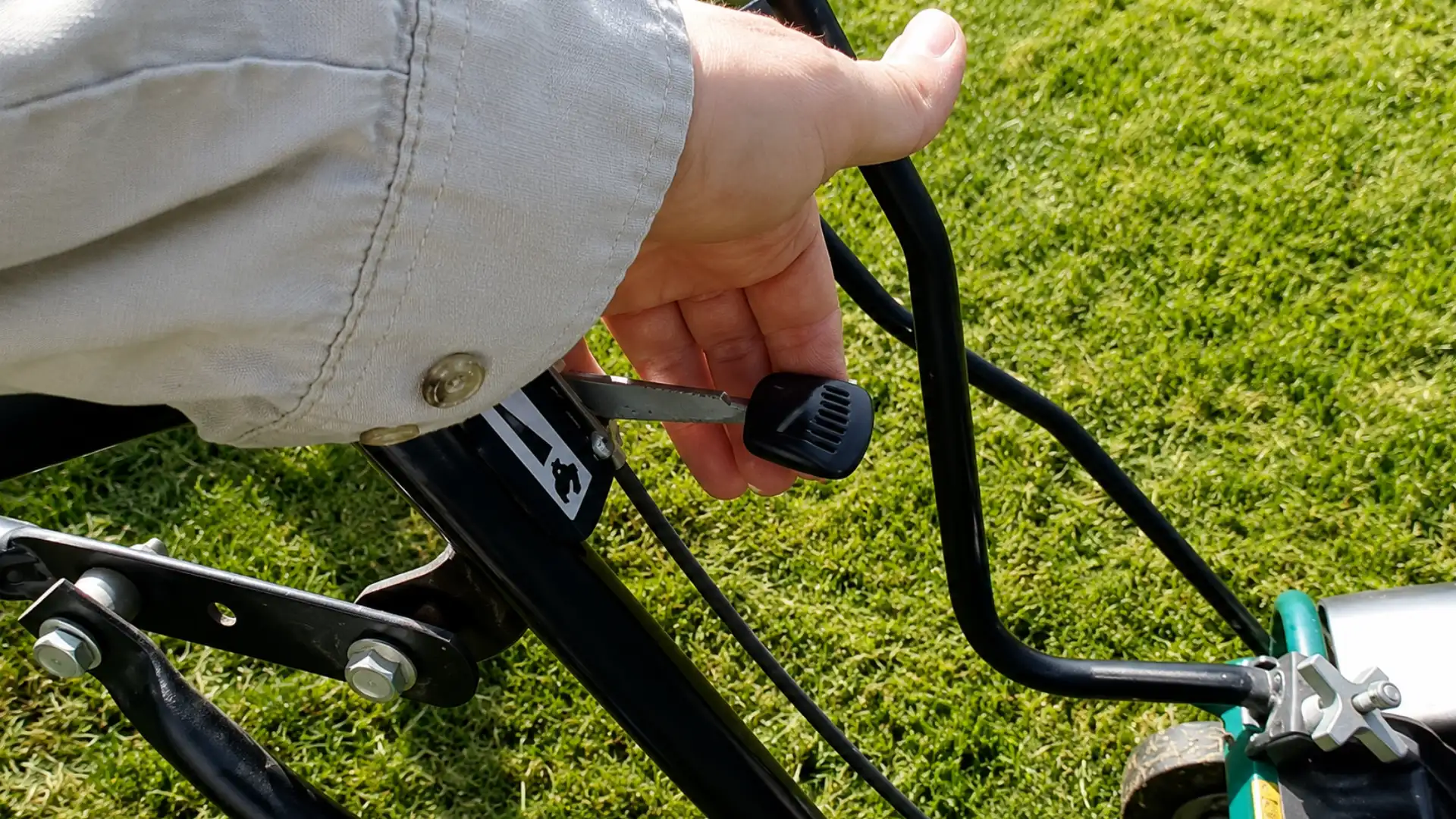 hand turning black throttle lever fully open on core aerator handlebar before running it