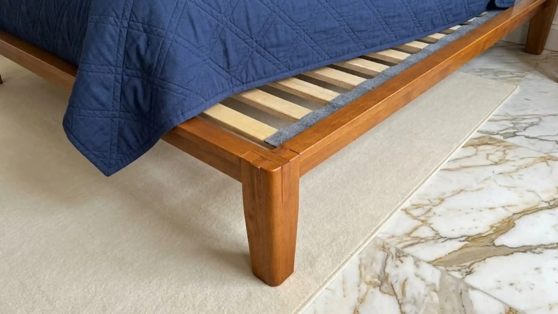 wooden bed frame with padded slats designed to reduce friction and stop squeaking