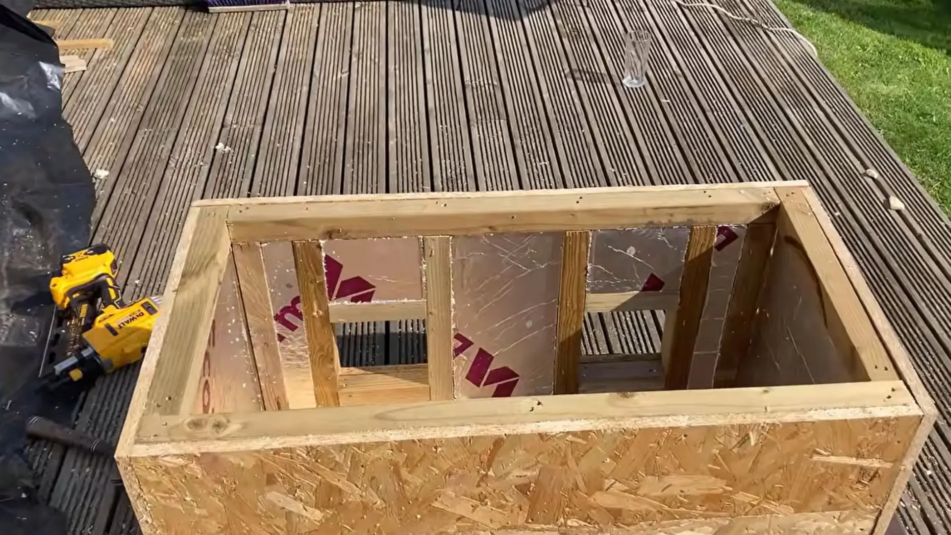 open wooden box frame showing insulation sheets fitted tightly between each of the wall studs