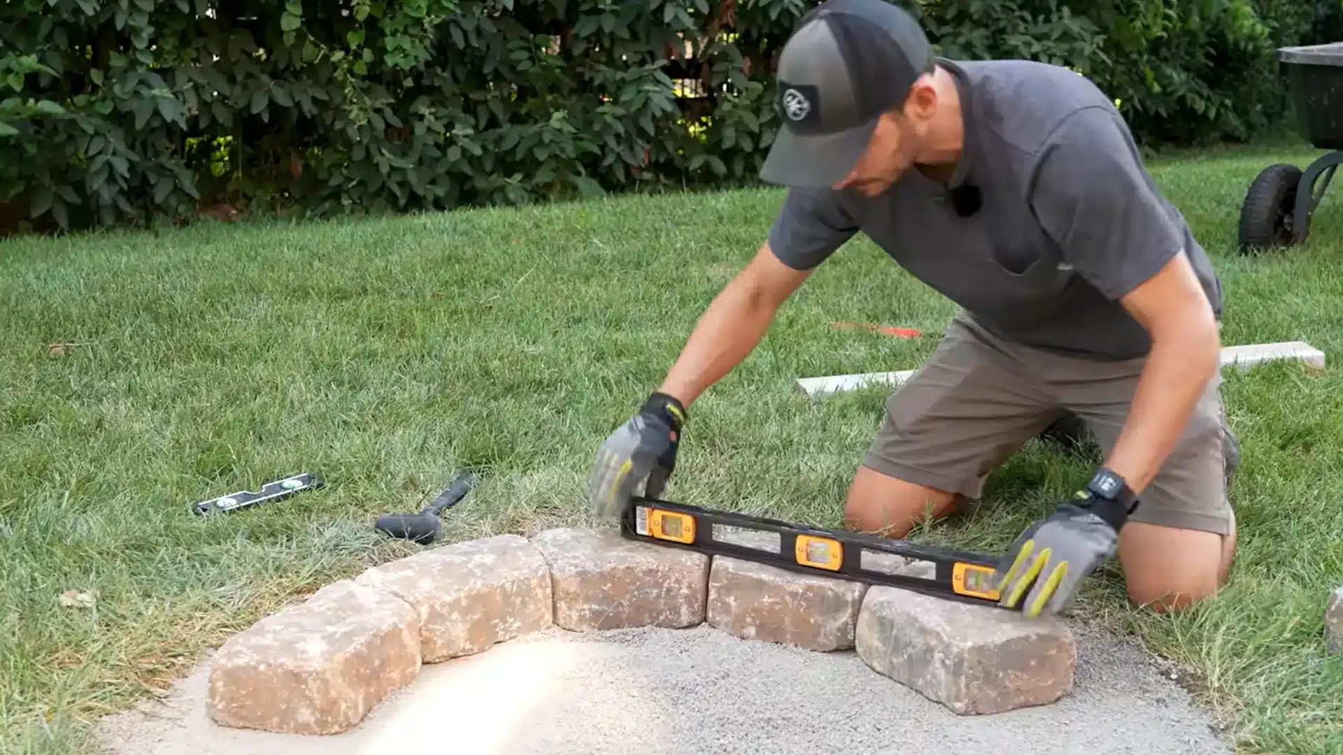 Placing the first row of concrete blocks in a circle for a fire pit base