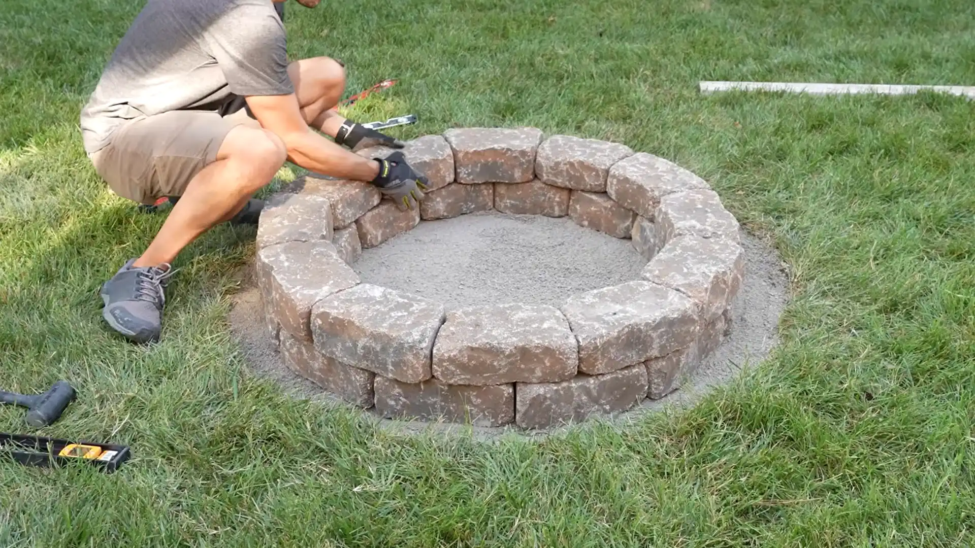 Stacking offset layers of concrete blocks to build fire pit walls