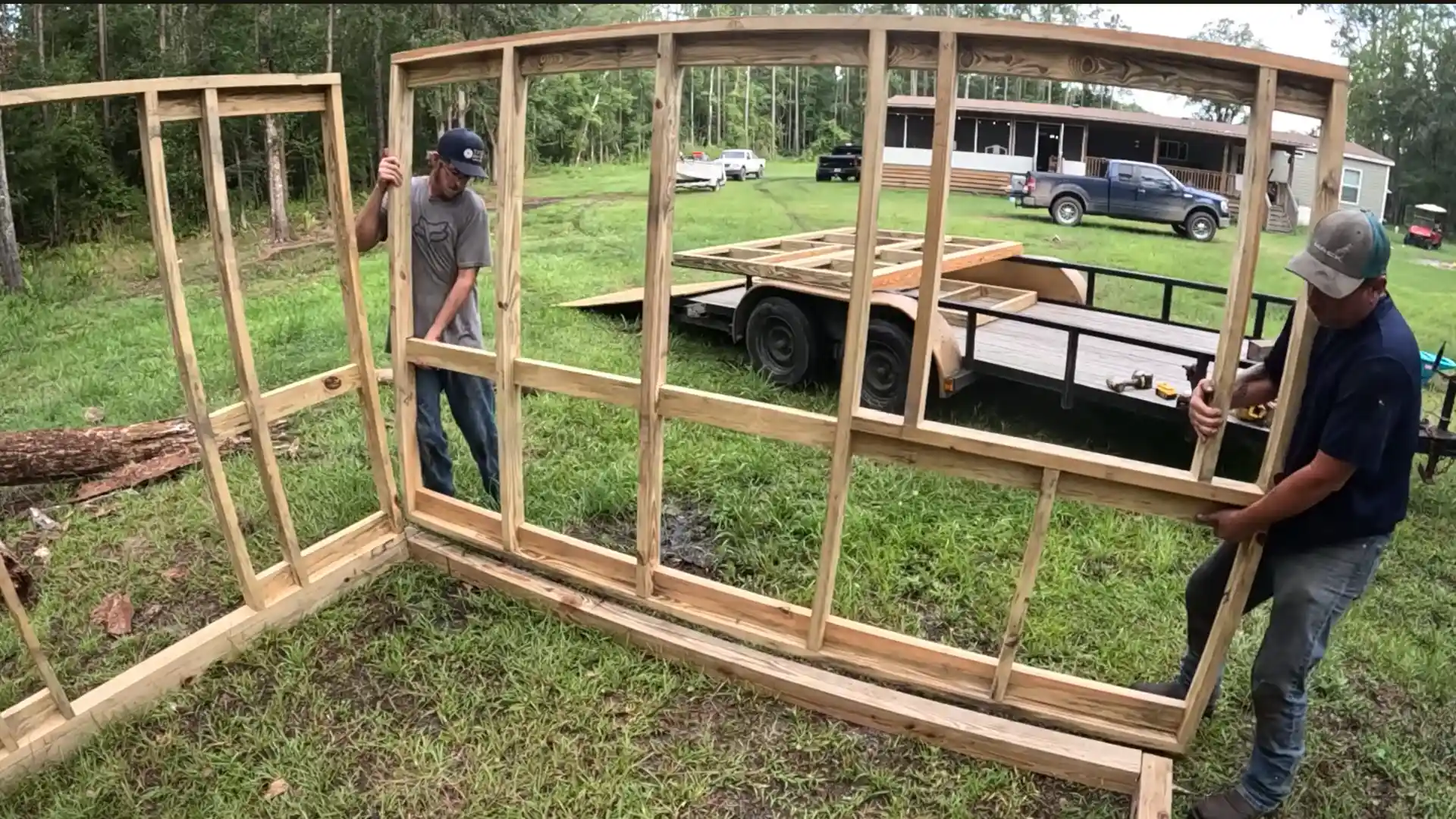 two builders raising wall frames outdoors while constructing a diy chicken coop