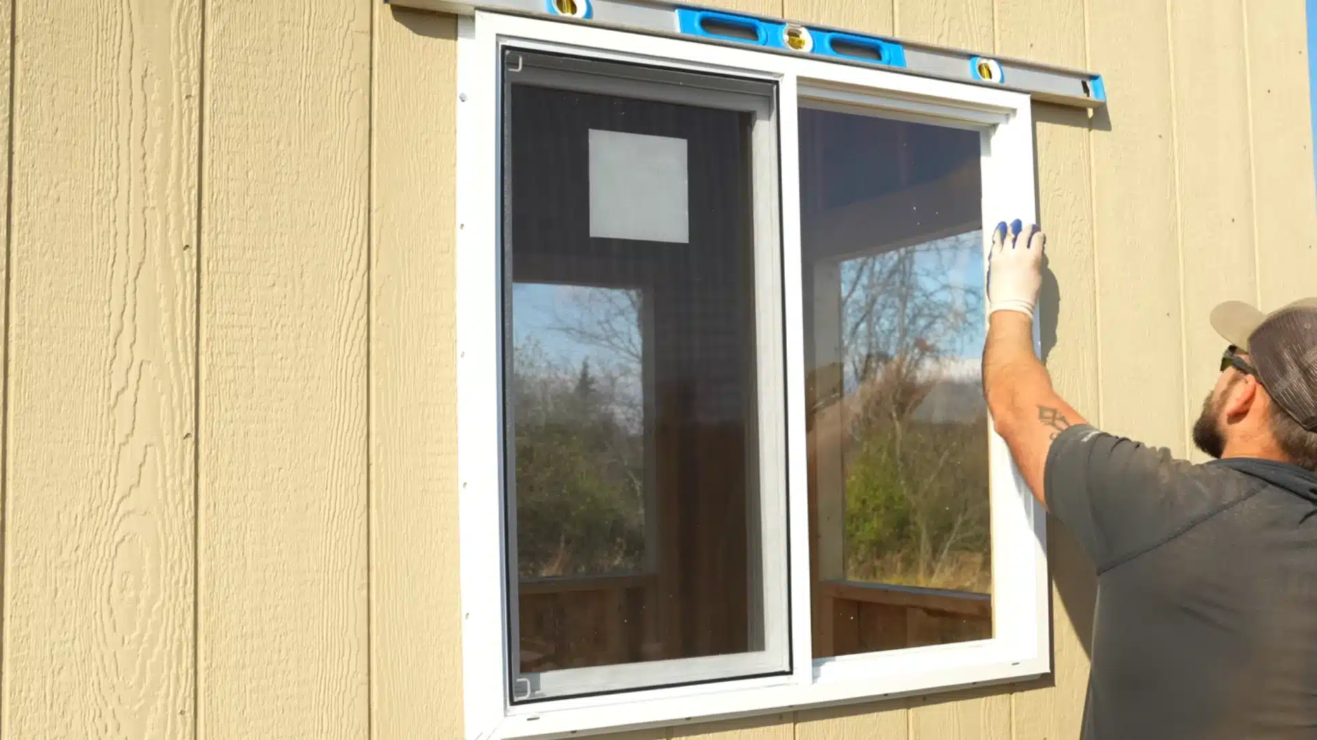 window and door installation showing man fitting white framed window and door